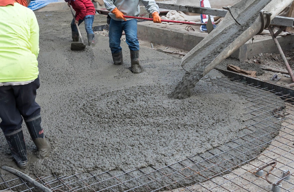 Concrete workers pouring a reinforced slab foundation over rebar in Camarillo, CA